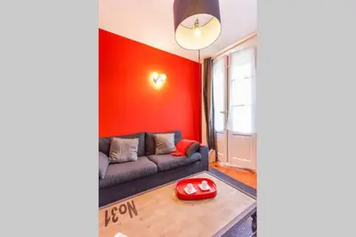 a living room with a couch and a red wall at L'Entrecasteaux in Aix-en-Provence
