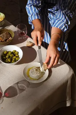 a table with a plate of food and bottles of wine at Le Galinier Lourmarin, a Beaumier Guesthouse in Lourmarin