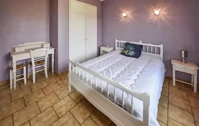 a bedroom with a white bed and a table and a desk at Maison provençale avec cheminée à Loriol-du-Comtat, jardin privatif in Loriol-du-Comtat