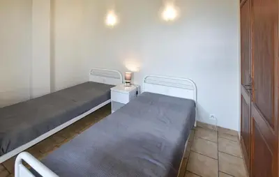 a small room with two beds and a night stand at Maison provençale avec cheminée à Loriol-du-Comtat, jardin privatif in Loriol-du-Comtat
