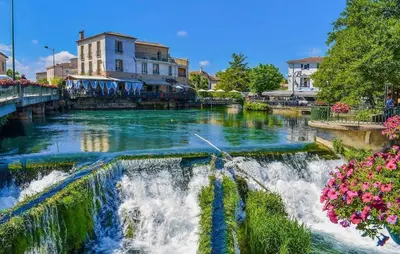 a river with a waterfall in a city at Maison provençale avec cheminée à Loriol-du-Comtat, jardin privatif in Loriol-du-Comtat