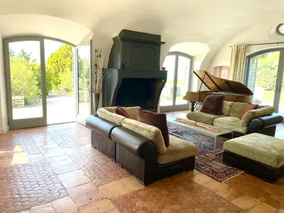a living room with a couch and a piano at Domaine de l'Enclos in Gordes