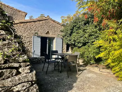 a table and chairs in front of a brick building at Domaine de l'Enclos in Gordes