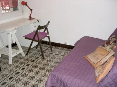 a purple bed and a chair in a room at Maison charmante avec terrasse et jardin à Noves in Noves