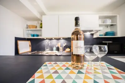 a bottle of wine sitting on a table with two wine glasses at LEYDET in Aix-en-Provence