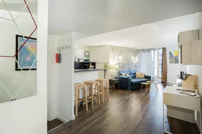 a living room and a kitchen with a couch at LEYDET in Aix-en-Provence