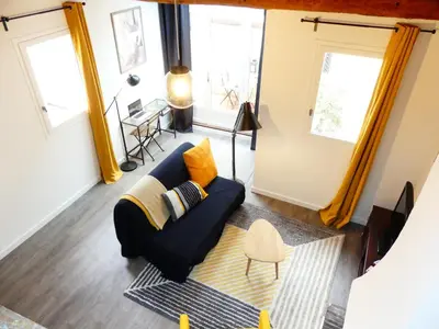 a living room with a blue couch and two windows at Les Bernardines in Aix-en-Provence