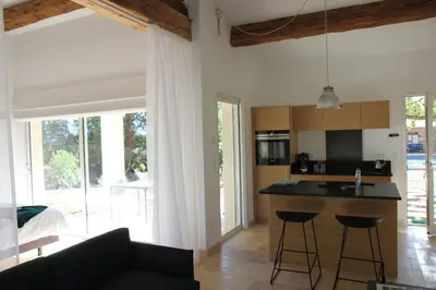 a kitchen and living room with a black counter top at Le Fournil en Provence in Caseneuve