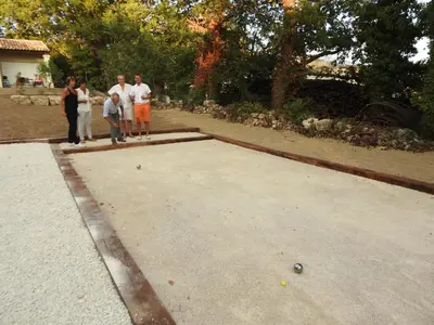 a group of people standing around a ping pong court at Le Fournil en Provence in Caseneuve