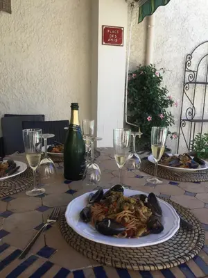 a table with a plate of food and wine glasses at authentic provencal mas with pool, in the countryside of the village of sénas, close to the luberon and the alpilles, sleeps 8. in Sénas