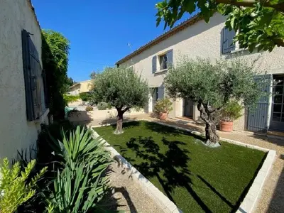 a garden with trees in the middle of a house at authentic provencal mas with pool, in the countryside of the village of sénas, close to the luberon and the alpilles, sleeps 8. in Sénas