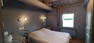 a bedroom with a white bed and a window at Chambres & Tables d'hôtes Moulin de Lavon in Gargas