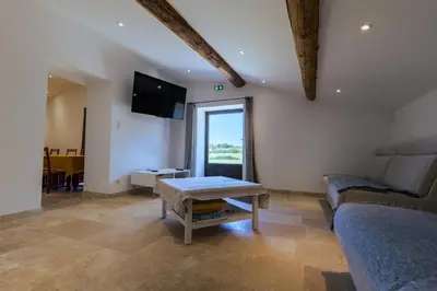 a living room with a couch and a table at Chambres & Tables d'hôtes Moulin de Lavon in Gargas