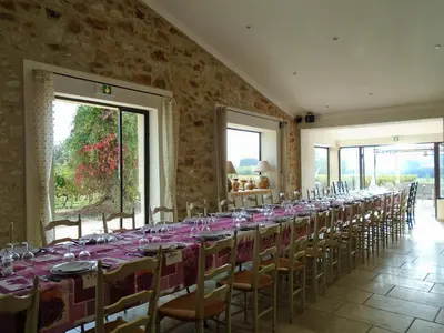 a long table in a room with tables and chairs at Chambres & Tables d'hôtes Moulin de Lavon in Gargas