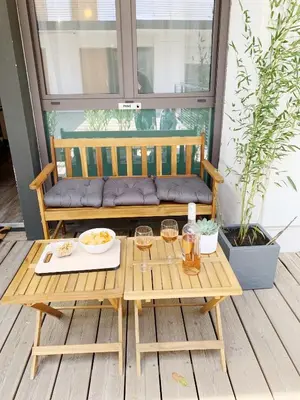 a wooden bench on a porch with a table at Appart Hôtel Cézanne in Aix-en-Provence