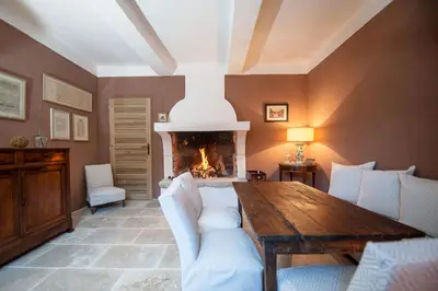 a living room with a table and a fireplace at La Ressence Luberon in Bonnieux