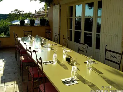 a long table is set on a patio at AU PIED DU VENTOUX in Flassan