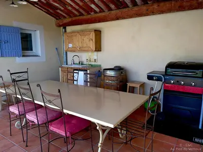 a kitchen with a table and chairs and a stove at AU PIED DU VENTOUX in Flassan