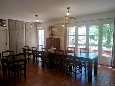 a dining room with a long table and chairs at AU PIED DU VENTOUX in Flassan