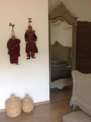 a room with a mirror and two statues on the wall at Petite Maison du Ventoux in Mormoiron