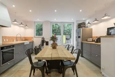 a kitchen with a wooden table and chairs in it at Petite Maison du Ventoux in Mormoiron