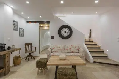 a living room with a couch and a clock on the wall at Petite Maison du Ventoux in Mormoiron