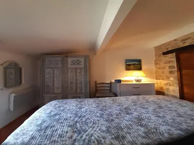 a bedroom with a bed and a desk with a lamp at Splendid Villa in Viens with Swimming Pool in Viens