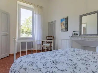 a bedroom with a bed and a fireplace and a window at Holiday Home Bastide du 19ième by Interhome in Oppède