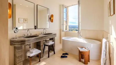 a bathroom with two sinks and a tub and a large window at Hotel Crillon le Brave in Crillon-le-Brave