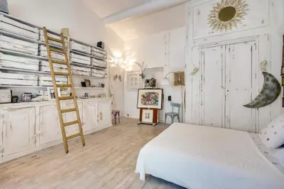 a bedroom with a ladder and a bed in a room at Le Mas des Anges in Cheval-Blanc