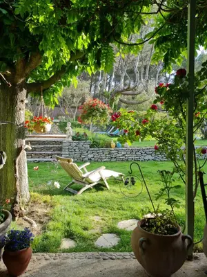 a garden with a chair and flowers in a yard at Le Mas des Anges in Cheval-Blanc