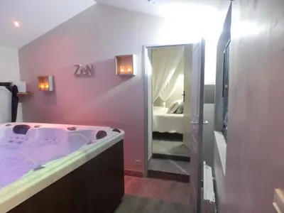 a bathroom with a large tub and a bedroom at Suite luxe avec sauna et jacuzzi privée in Lambesc