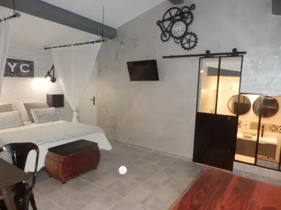 a hotel room with a bed and a table at Suite luxe avec sauna et jacuzzi privée in Lambesc