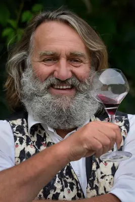 an older man holding a glass of wine at Le Domaine Saint Jean in Saint-Saturnin-les-Apt