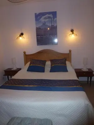 a bedroom with a large bed with blue pillows at Chambre d'hôtes La Pinede in Lambesc