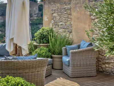 two wicker chairs and an umbrella on a patio at Villa Sunset in Gordes in Gordes