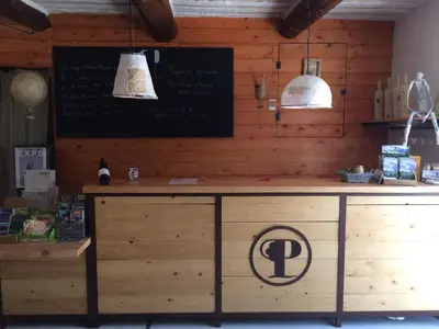 a wooden counter with a sign on the wall at Le Mas de Plein Pagnier in Mazan