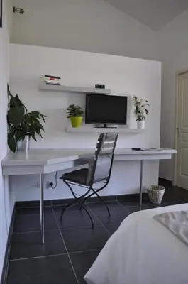 a desk with a monitor and a chair in a bedroom at Le Mas de Plein Pagnier in Mazan