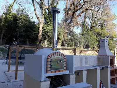 a wood fired pizza oven in a yard at Gîte de Léonie Moulin de Tartay en Avignon in Avignon