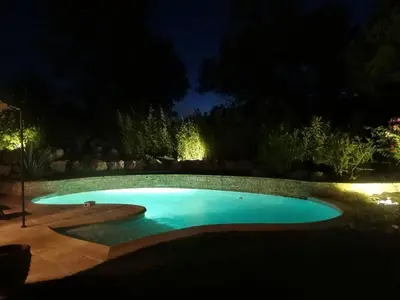 a swimming pool in a yard at night at Golf de Pont Royal Villa du Lac climatisée 3 chambres Piscine chauffée Parking et Garage in Mallemort