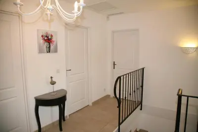 a hallway with a black table and a chandelier at Golf de Pont Royal Villa les Micocouliers climatisée 4 chambres Piscine chauffée Parking in Mallemort