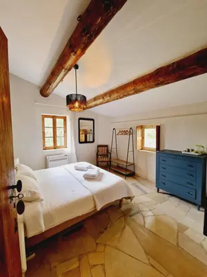 a bedroom with a large bed and a blue dresser at Mas du Rollier Chambres d'hôtes in Eygalières