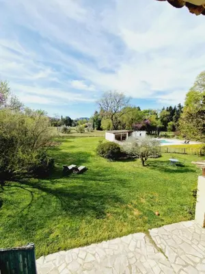 a grassy yard with a building in the background at Mas du Rollier Chambres d'hôtes in Eygalières
