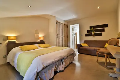 a bedroom with a large bed and a couch at Le Mas de la Lombarde in Lourmarin