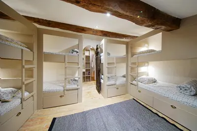 a room with four bunk beds and a blue rug at Mas des Baussiers in Saint-Martin-de-Castillon