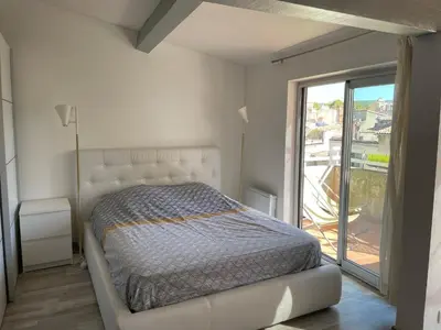 a bedroom with a bed and a large window at Appart Centre Mairie - Terrasse vue Ste Victoire in Aix-en-Provence