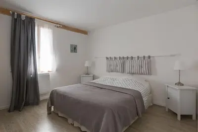 a white bedroom with a bed and a window at Lou Cardalines in Bédoin