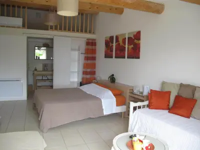a bedroom with two beds and a table with a bowl of fruit at Lou Cardalines in Bédoin
