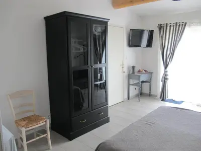 a bedroom with a black cabinet and a chair at Lou Cardalines in Bédoin