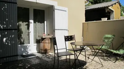 a patio with a table and chairs next to a building at Lou Cardalines in Bédoin